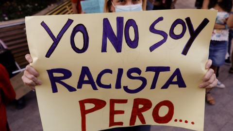 Una persona con una pancarta durante una concentración contra el odio y el racismo.