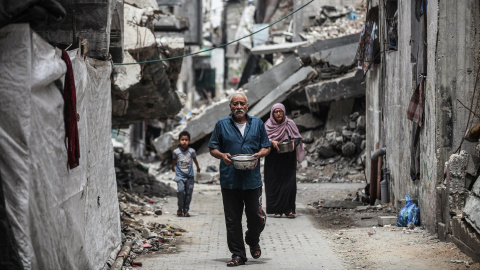 Personas desplazadas se reúnen para recibir comidas de un comedor benéfico en el campamento de refugiados de al-Bureij, en el centro de la Franja de Gaza, el 15 de mayo de 2026.