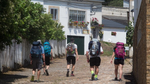 Un grupo de peregrinos realiza el Camino de Santiago a su paso por Portomarín (Lugo). Un grupo de peregrinos realiza el Camino de Santiago a su paso por Portomarín (Lugo).
