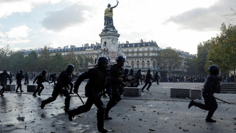 Agentes de la Policía avanzan con determinación en la Plaza de la República de París durante una manifestación contra el alto costo de la vida.