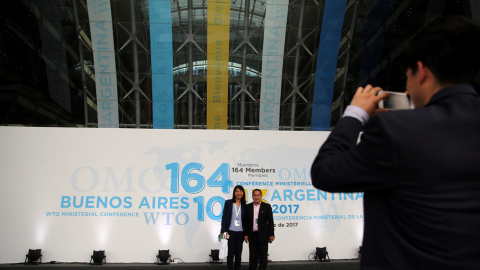 Dos personas posan para una foto en la entrada del centro donde se ha celebrado en Buenos Aires la undécima Conferencia Ministerial de la OMC. REUTERS/Marcos Brindicci Dos personas posan para una foto en la entrada del centro donde se ha celebrado en Buenos Aires la undécima Conferencia Ministerial de la OMC. REUTERS/Marcos Brindicci