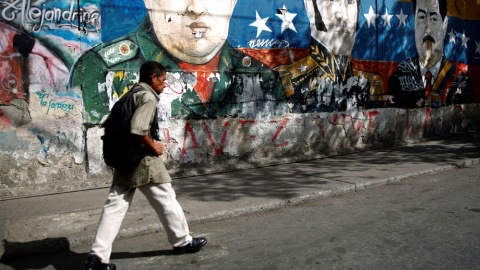 Un hombre camina junto a unos graffitis del héroe revolucionario sudamericano Simón Bolívar, el fallecido presidente de Venezuela, Hugo Chávez y el presidente de Venezuela, Nicolás Maduro, en el barrio José Félix Ribas en Caracas. REUTERS / Carlos Un hombre camina junto a unos graffitis del héroe revolucionario sudamericano Simón Bolívar, el fallecido presidente de Venezuela, Hugo Chávez y el presidente de Venezuela, Nicolás Maduro, en el barrio José Félix Ribas en Caracas. REUTERS / Carlos