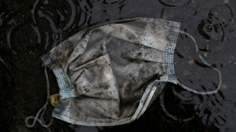 Una mascarilla, tirada en un charco en el suelo, en Madrid, durante el estado de alarma por la pandemia del coronavirus. REUTERS/Susana Vera Una mascarilla, tirada en un charco en el suelo, en Madrid, durante el estado de alarma por la pandemia del coronavirus. REUTERS/Susana Vera