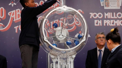 Uno de los niños de San Ildefonso intruduce las bolas en el bombo para el sorteo de la lotería de El Niño. EFE/ Zipi
Uno de los niños de San Ildefonso intruduce las bolas en el bombo para el sorteo de la lotería de El Niño. EFE/ Zipi