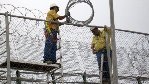 Dos operarios reparando la concertina de la valla que separa España y Marruecos, en Melilla. EFE Dos operarios reparando la concertina de la valla que separa España y Marruecos, en Melilla. EFE