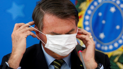El presidente de Brasil, Jair Bolsonaro, se ajusta la mascarilla, en una comparecencia en Brasilia. REUTERS/Adriano Machado El presidente de Brasil, Jair Bolsonaro, se ajusta la mascarilla, en una comparecencia en Brasilia. REUTERS/Adriano Machado