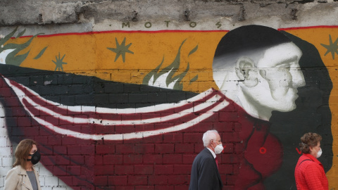 Varias personas con mascarilla pasan por delante de un graffiti en una calle de Madrid. REUTERS/Susana Vera Varias personas con mascarilla pasan por delante de un graffiti en una calle de Madrid. REUTERS/Susana Vera