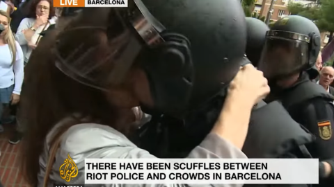 Captura del video de Al Jazeera en el que se ve a una activista besar a uno de los antidisturbios que cargaron en la jornada del 1-0. Captura del video de Al Jazeera en el que se ve a una activista besar a uno de los antidisturbios que cargaron en la jornada del 1-0.