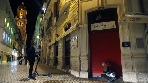 Un camarero cierra el bar ubicado en el centro de Málaga, como consecuencia del toque de queda impuesto por el Gobierno para poder frenar el coronavirus. E.P./Álex Zea Un camarero cierra el bar ubicado en el centro de Málaga, como consecuencia del toque de queda impuesto por el Gobierno para poder frenar el coronavirus. E.P./Álex Zea