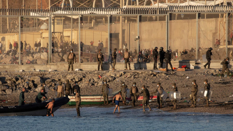 Miembros del ejército ayudan a dos inmigrantes a su llegada a la playa de El Tarajal, junto a la valla fronteriza , en Ceuta este miércoles.- EFE Miembros del ejército ayudan a dos inmigrantes a su llegada a la playa de El Tarajal, junto a la valla fronteriza , en Ceuta este miércoles.- EFE