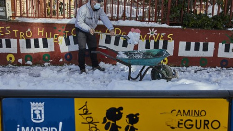 Un familiar colabora en la limpieza del hielo y la nieve en las inmediaciones del colegio Amadeo Vives tras la gran nevada por el paso de la borrasca 'Filomena', en Madrid, (España), a 16 de enero de 2021. Europa Press Familias colaboran en la limpieza del hielo del Colegio Amadeo Vives (Madrid)
