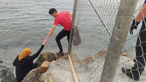 Dos inmigrantes escalan las rocas de uno de los espigones fronterizos de Ceuta, donde ayer se batió la cifra récord de llegada de inmigrantes a España en un solo día por vía marítima, contabilizando los 5000 marroquíes que según la delegación de Dos inmigrantes escalan las rocas de uno de los espigones fronterizos de Ceuta, donde ayer se batió la cifra récord de llegada de inmigrantes a España en un solo día por vía marítima, contabilizando los 5000 marroquíes que según la delegación de