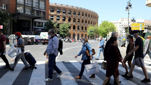 Varias personas, muchas con mascarilla, cruzan la calle cerca de la Plaza de Toros de Valencia. REUTERS/Nacho Doce Varias personas, muchas con mascarilla, cruzan la calle cerca de la Plaza de Toros de Valencia. REUTERS/Nacho Doce