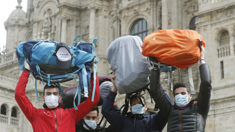 13/03/2020.- Peregrinos muestran sus mochilas mientras se protegen con mascarillas al terminar el Camino a pesar de la crisis del coronavirus. / EFE - LAVANDEIRA JR 13/03/2020.- Peregrinos muestran sus mochilas mientras se protegen con mascarillas al terminar el Camino a pesar de la crisis del coronavirus. / EFE - LAVANDEIRA JR