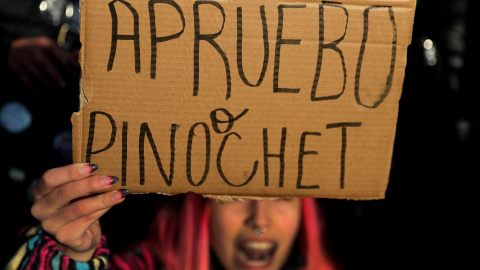Una manifestante sostiene una pancarta en la que se lee "Apruebo o Pinochet" / REUTERS Una manifestante sostiene una pancarta en la que se lee "Apruebo o Pinochet" / REUTERS