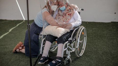 Una interna en una residencia de mayores en València abraza a su hija a través de un plástico habilitado para que los familiares se puedan dar su primer abrazo desde hace tres meses. - EFE/Biel Aliño Una interna en una residencia de mayores en València abraza a su hija a través de un plástico habilitado para que los familiares se puedan dar su primer abrazo desde hace tres meses. - EFE/Biel Aliño