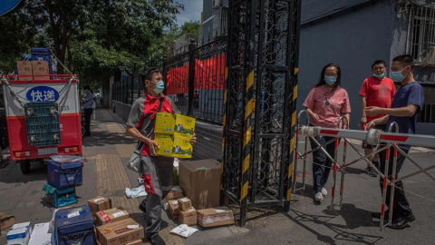 Un repartidor entrega paquetes para los residentes en un complejo residencial cerrado cerca del mercado de Yuquandong, en el distrito de Haidian, Pekín, China. EFE/EPA/ROMAN PILIPEY Un repartidor entrega paquetes para los residentes en un complejo residencial cerrado cerca del mercado de Yuquandong, en el distrito de Haidian, Pekín, China. EFE/EPA/ROMAN PILIPEY