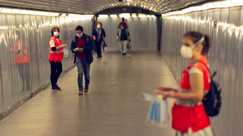 GRAFCAT5817. BARCELONA, 04/05/2020.- Voluntarias de la Cruz Roja reparte mascarillas en el Metro de Barcelona, este lunes, primer día en el que el uso de mascarillas en el transporte público es obligatorio, en el inicio de la fase 0 del plan de desescal GRAFCAT5817. BARCELONA, 04/05/2020.- Voluntarias de la Cruz Roja reparte mascarillas en el Metro de Barcelona, este lunes, primer día en el que el uso de mascarillas en el transporte público es obligatorio, en el inicio de la fase 0 del plan de desescal