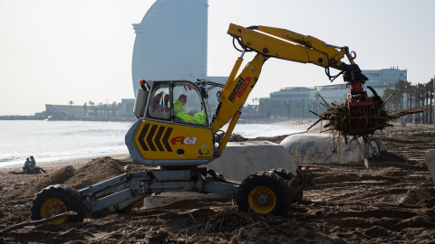 Un operario recoge parte de los desperfectos provocados por el temporal 'Gloria' en la playa de Barcelona. (Josep Lago-AFP) Un operario recoge parte de los desperfectos provocados por el temporal 'Gloria' en la playa de Barcelona. (Josep Lago-AFP)