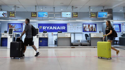 Dos pasajeros pasan antes los mostradores de la aerolínea Ryanair en la T-1 del aeropuerto Adolfo Suárez Madrid-Barajas. (FERNANDO VILLA) Dos pasajeros pasan antes los mostradores de la aerolínea Ryanair en la T-1 del aeropuerto Adolfo Suárez Madrid-Barajas. (FERNANDO VILLA)