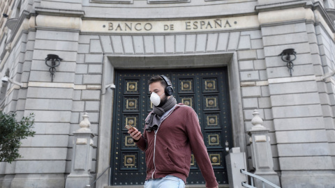 Un hombre con una mascarilla pasa junto a las oficinas del Banco de España, en Barcelona. REUTERS/Nacho Doce Un hombre con una mascarilla pasa junto a las oficinas del Banco de España, en Barcelona. REUTERS/Nacho Doce
