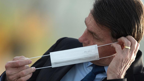 El presidente de Brasil, Jair Bolsonaro, se pone una mascarilla durante una ceremonia oficial, el 9 de junio de 2020, en el Palacio do Alvorada. EFE/ Joédson Alves. El presidente de Brasil, Jair Bolsonaro, se pone una mascarilla durante una ceremonia oficial, el 9 de junio de 2020, en el Palacio do Alvorada. EFE/ Joédson Alves.
