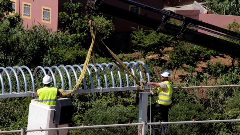 El personal encargado de las obras de reforma del perímetro fronterizo que separa Ceuta de Marruecos instala los primeros tubo antitrepados que sustituyen a las concertinas que coronaban el vallado fronterizo. EFE/ Reduan Dris El personal encargado de las obras de reforma del perímetro fronterizo que separa Ceuta de Marruecos instala los primeros tubo antitrepados que sustituyen a las concertinas que coronaban el vallado fronterizo. EFE/ Reduan Dris