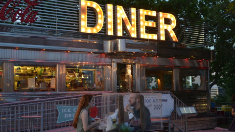 En los Autocines Madrid Race, una pareja come separados por una mampara de otra mesa. JOSE CARMONA. En los Autocines Madrid Race, una pareja come separados por una mampara de otra mesa. JOSE CARMONA.