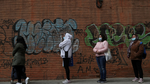 Personas haciendo cola para recibir alimentos donados por voluntarios de la asociación Vecinos Parque Aluche, en Madrid, durante el estado de alarma por la pandemia del coronavirus. REUTERS / Susana Vera Personas haciendo cola para recibir alimentos donados por voluntarios de la asociación Vecinos Parque Aluche, en Madrid, durante el estado de alarma por la pandemia del coronavirus. REUTERS / Susana Vera