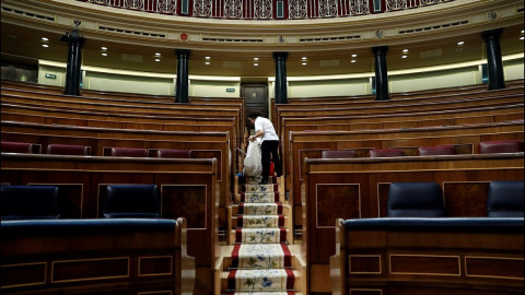 Una empleada de la Cámara limpia el hemiciclo del Congreso vacío Una empleada de la Cámara limpia el hemiciclo del Congreso vacío