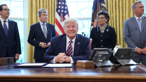 El presidente de los Estados Unidos, Donald Trump, sonríe, flanqueado por el secretario del Tesoro Steven Mnuchin, el senador Roy Blunt, la reponsable de la Oficina para las Pequeñas Empresas, Jovita Carranza y el líder de la minoría de la Cámara Kev