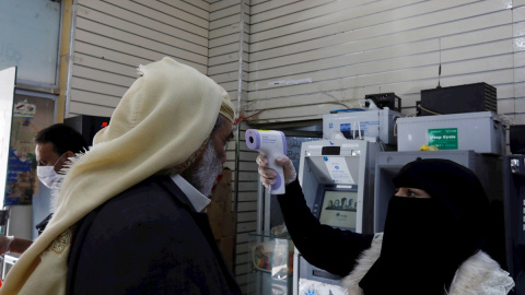Una trabajadora comprueba la temperatura de un consumidor en un supermercado de Yemen.- EFE Una trabajadora comprueba la temperatura de un consumidor en un supermercado de Yemen.- EFE