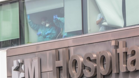 Sanitarios del Hospital de La Paz totalmente protegidos saludan y agradecen el apoyo desde una de las ventanas del centro donde se lucha contra el coronavirus, en Madrid (España) Sanitarios del Hospital de La Paz totalmente protegidos saludan y agradecen el apoyo desde una de las ventanas del centro donde se lucha contra el coronavirus, en Madrid (España)