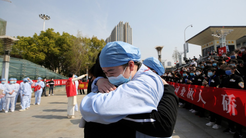 Dos enfermeros chinos se abrazan. REUTERS Dos enfermeros chinos se abrazan. REUTERS