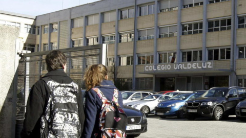 Dos jóvenes pasan por la puerta del colegio Valdeluz. /EFE Dos jóvenes pasan por la puerta del colegio Valdeluz. /EFE