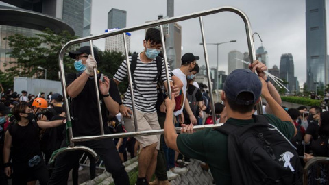 Manifestantes usan barreras para construir una barricada en una calle principal durante un mitin contra las enmiendas a un proyecto de ley de extradición cerca del Consejo Legislativo en Hong Kong. EFE / Jerome Favre