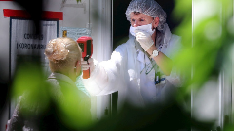 Una trabajadora sanitaria toma la temperatura a una persona. EFE/Archivo Una trabajadora sanitaria toma la temperatura a una persona. EFE/Archivo