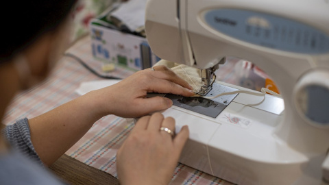 Una mujer cose una mascarilla. EFE/Jerome Favre Una mujer cose una mascarilla. EFE/Jerome Favre