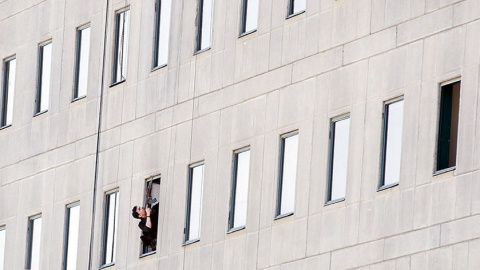 Miembro de las fuerzas de seguridad iranís apunta con su arma durante el ataque al Parlamento en el centro de Teherán. / REUTERS