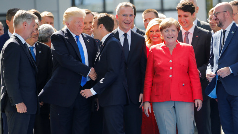 El Presidente estadounidense Donald Trump y su homólogo francés Emmanuel Macron se saludan con un apretón de manos frente a otros líderes mundiales en la Cumbre de la OTAN REUTERS/Jonathan Ernst