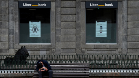 Un hombre sentado frente a la sede de Liberbank en Oviedo. REUTERS/Eloy Alonso Un hombre sentado frente a la sede de Liberbank en Oviedo. REUTERS/Eloy Alonso