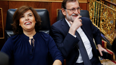 La vicepresidenta del Gobierno, Soraya Sáenz de Santamaría, y el presidente del Gobierno, Mariano Rajoy, se ríen antes de que comience el debate de moción de censura al Gobierno del PP. REUTERS/Juan Medina