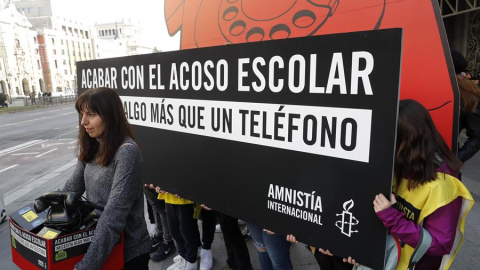 GRAF8275. MADRID, 28/02/2020.- Jóvenes activistas de Amnistía Internacional despliegan un teléfono de disco gigante en la puerta principal del Ministerio de Educación este viernes en Madrid para denunciar que el actual sistema de denuncias de acoso es GRAF8275. MADRID, 28/02/2020.- Jóvenes activistas de Amnistía Internacional despliegan un teléfono de disco gigante en la puerta principal del Ministerio de Educación este viernes en Madrid para denunciar que el actual sistema de denuncias de acoso es