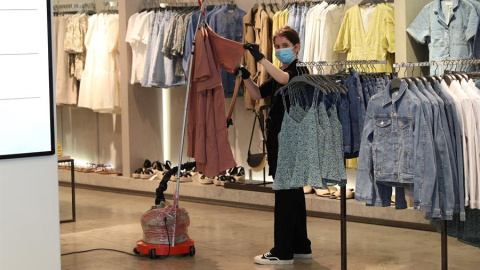 Una dependienta desinfecta la ropa con una plancha de vapor en el interior de una tienda. EFE/Rodrigo Jiménez Una dependienta desinfecta la ropa con una plancha de vapor en el interior de una tienda. EFE/Rodrigo Jiménez