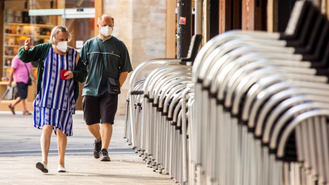 Un hombre y una mujer pasan ante la terraza recogida de un bar en el centro de Vitoria este miércoles, en el que se ha sabido que tres personas fallecieron la semana pasada en Euskadi con infección por coronavirus. EFE/ David Aguilar Un hombre y una mujer pasan ante la terraza recogida de un bar en el centro de Vitoria este miércoles, en el que se ha sabido que tres personas fallecieron la semana pasada en Euskadi con infección por coronavirus. EFE/ David Aguilar