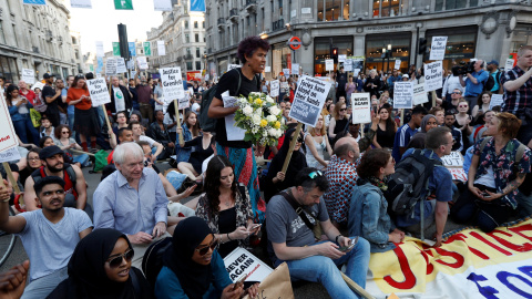 Manifestantes sentados en protesta por la falta de respuesta de las autoridades al incendio de Grenfell. /REUTERS