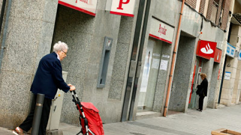 Una mujer pasa junto a una sucursal del Banco Popular en Barcelona. REUTERS/ Albert Gea Una mujer pasa junto a una sucursal del Banco Popular en Barcelona. REUTERS/ Albert Gea