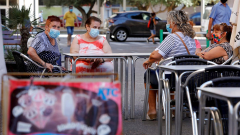 Una vecinas descansan en la terraza de un bar del barrio de la Pastoreta de Reus (Tarragona) donde este lunes se han reanudado los cribados masivos de PCR a los vecinos. /EFE Una vecinas descansan en la terraza de un bar del barrio de la Pastoreta de Reus (Tarragona) donde este lunes se han reanudado los cribados masivos de PCR a los vecinos. /EFE
