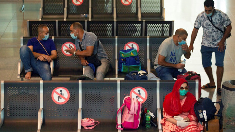 Viajeros con máscaras sanitarias descansan este miércoles en la Terminal 1 del aeropuerto Josep Tarradelles | EFE Viajeros con máscaras sanitarias descansan este miércoles en la Terminal 1 del aeropuerto Josep Tarradelles | EFE