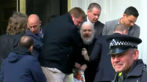 Julian Assange, con un libro de Gore Vidal en la mano, en el momento de su detención, en Londres. Julian Assange, con un libro de Gore Vidal en la mano, en el momento de su detención, en Londres.